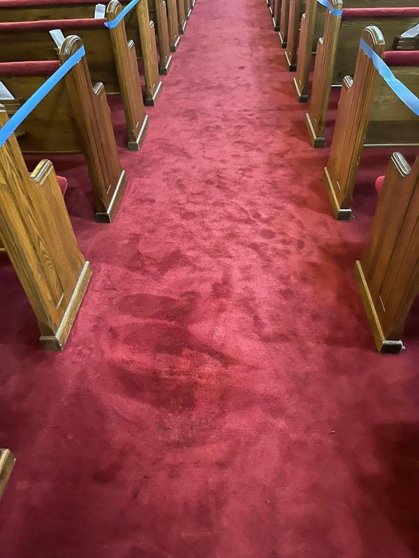 Red carpet along a church aisle between timber pews
